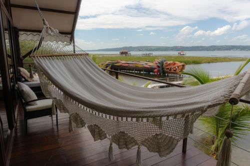 a hammock on a balcony with a view of a river at Cabaña Jaguar in Flores