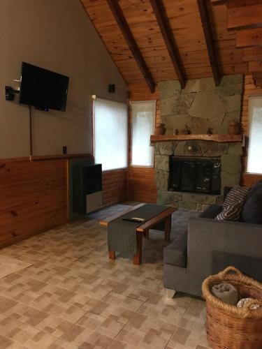 a living room with a couch and a stone fireplace at Mi lugar con Mily in Villa La Angostura
