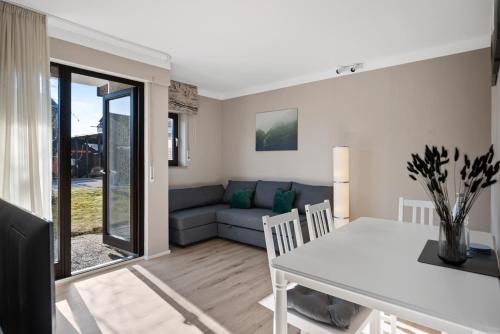 a living room with a white table and a couch at Schwarzwald Moment am Monbachtal in Bad Liebenzell