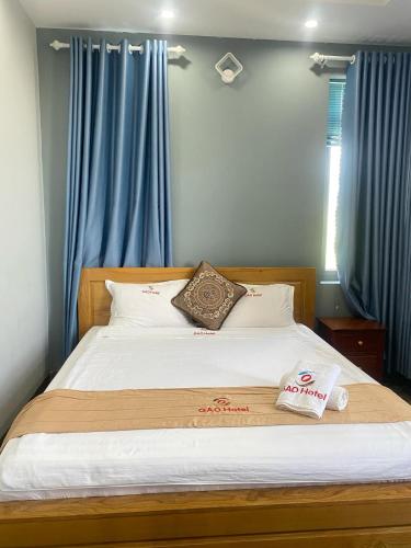 a bedroom with a large bed with blue curtains at Gao Hotel in Con Dao