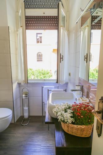 a bathroom with a sink and a tub with a basket of flowers at Villa Matissa in Rome