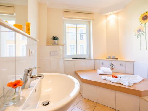 a white bathroom with a sink and a window at holiday apartment with 2 bedrooms in Ostseebad Karlshagen