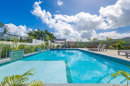 a large swimming pool with blue water at Modern, Spacious, 3BR Hill View Retreat, Central, Gated in Ocho Rios