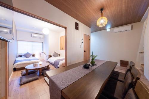 a room with a dining table and a bedroom at とき 全面改装した町屋 伏見稲荷大社そばで ベッド8台 3寝室 トイレ2台 in Kyoto