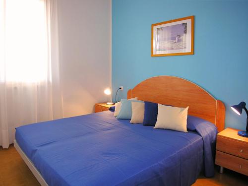 ビビオーネにあるAppartamenti Villaggio San Siroの青いベッドルーム(大型ベッド1台、青いシーツ付)