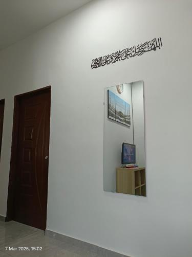 a room with a door and a mirror on a wall at Homestay Tok Abah Jasin in Jasin