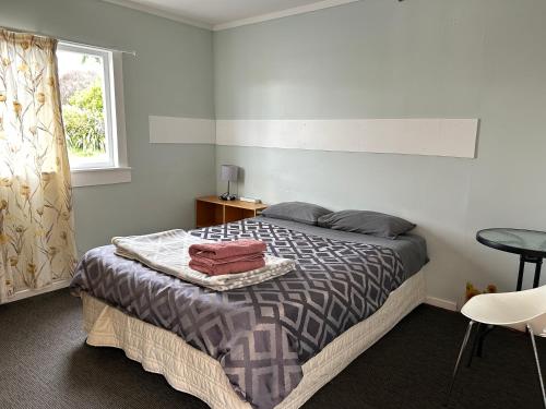 a bedroom with a bed with a table and a window at National Park Alpine Lodge in National Park