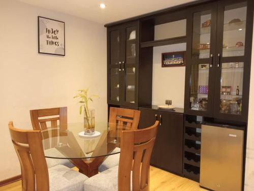 a dining room with a glass table and chairs at Spacious Apartment - Los Olivos in Lima