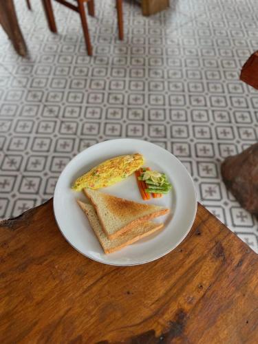 un plato blanco con dos sándwiches en una mesa en SUN RESORT GILI TRAWANGAN, en Gili Trawangan