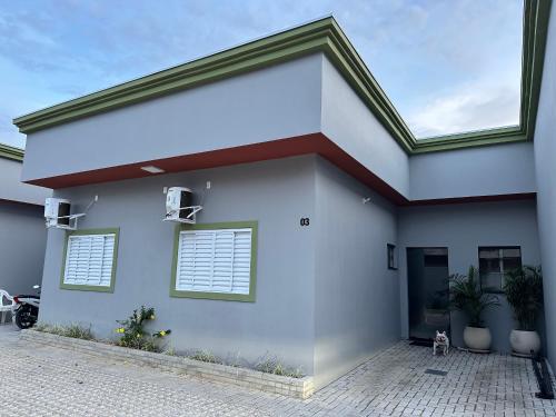 a white house with two windows on it at Casa 2 quartos, completa, com churrasqueira e garagem - Villa Bella in Nova Mutum