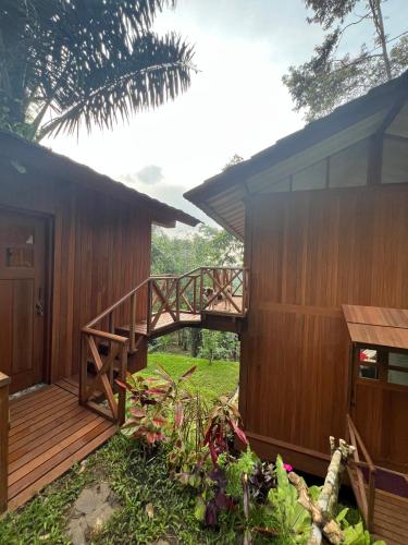 a house with a wooden deck next to a building at The Lookout Cabin in Pupuan Tabanan Bali in Tabanan
