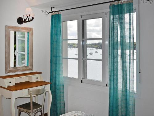 Cette chambre dispose d'un bureau et d'une fenêtre avec des rideaux verts. dans l'établissement Holiday Home in Térenez with Sea View, à Plougasnou