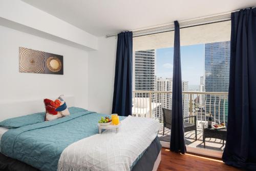 a bedroom with a bed and a balcony with a view at Two Bedroom Oceanview Apartment in Brickell in Miami