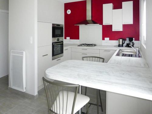 - une cuisine avec des placards blancs et des murs rouges dans l'établissement House in Saint-Quay near 7 Beaches, à Saint-Quay-Portrieux