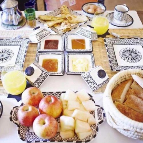 einen Tisch mit Äpfeln und anderen Lebensmitteln darauf in der Unterkunft Desert Nomads Camp in Merzouga