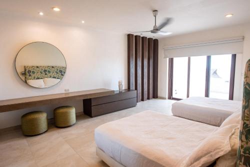 a bedroom with two beds and a mirror at Casa Linda, Paraíso de 4 recámaras en la Playa in Chicxulub