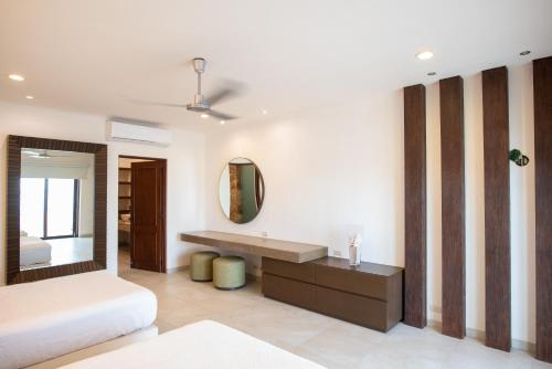 a bedroom with a bed and a mirror at Casa Linda, Paraíso de 4 recámaras en la Playa in Chicxulub