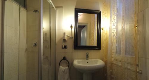 a bathroom with a sink and a shower with a mirror at La Casa del Viandante in Modena