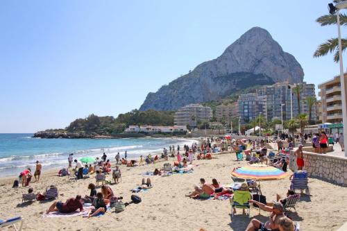 a crowd of people on a beach with a mountain at La Luz Costa Calpe in Calpe
