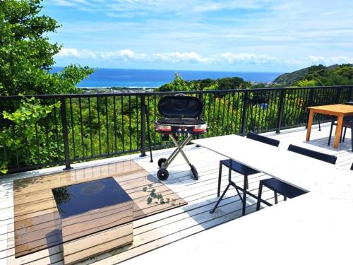 a grill on a deck with the ocean in the background at Natuur one Kamogawa in Minamiboso