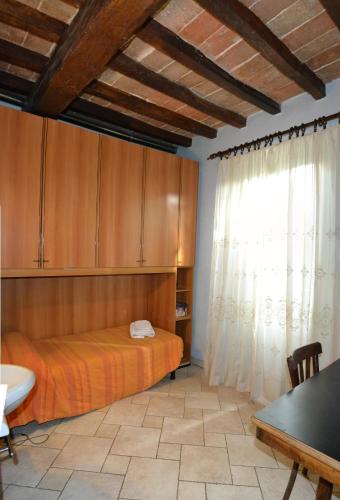 a bedroom with a bed and wooden cabinets and a window at La Casa del Viandante in Modena