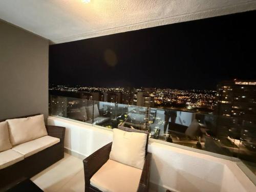 a room with a window with a view of a city at Departamento Nuevo Costa del Mar Concón in Concón