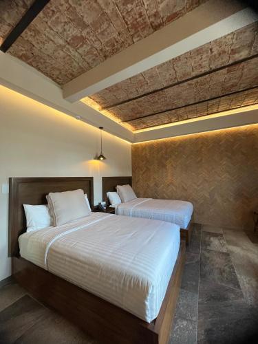 two beds in a hotel room with two bedsvisor at Hotel Boutique Divino Sol in León