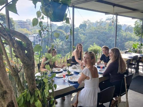 a group of people sitting at a table eating food at Green Peak - Mountain View Hotel & Restaurant in Ella