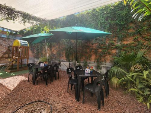 a group of tables and chairs with umbrellas at Suite 3 en Tlaquepaque centro in Guadalajara