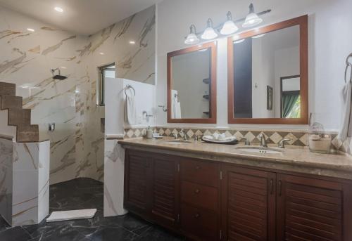 a bathroom with two sinks and a large mirror at Villa Beach Adventure Relax Holiday Private Pool BBQ Maid Service Golf in Playa del Carmen
