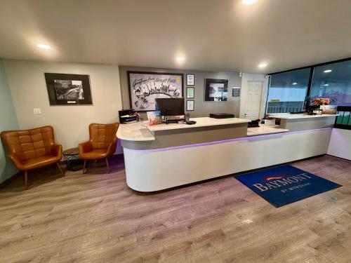 an office with a desk with a computer and chairs at Baymont by Wyndham Great Falls City Center in Great Falls