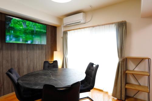 a dining room with a table and chairs and a television at ウエストワン サウス 306 in Hitoyoshi