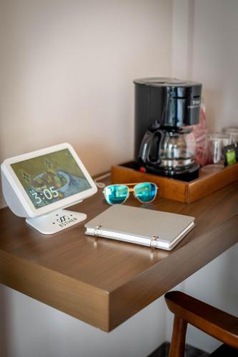 a table with a coffee maker and a laptop and glasses at Hotel Boutique Divino Sol in León