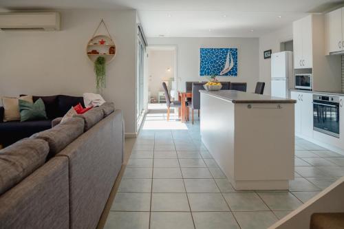 a living room and kitchen with a couch and a counter at Kidman at Boardwalk Villas in Metung