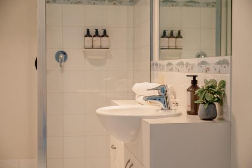 a white bathroom with a sink and a shower at Kidman at Boardwalk Villas in Metung