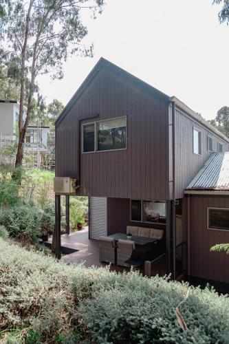 a brown house with a table in front of it at Kidman at Boardwalk Villas in Metung