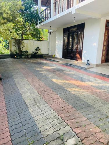 a cobblestone driveway in front of a building at Fine Homes in Kalutara