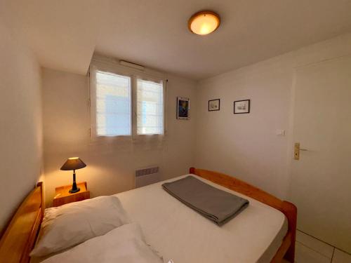 une petite chambre avec un lit et une fenêtre dans l'établissement Appartement T2 + Mezzanine avec 2 Salles d'Eau et Parking Privé, Bord de Mer - St-Hilaire-de-Riez - FR-1-323-336, à Saint-Hilaire-de-Riez