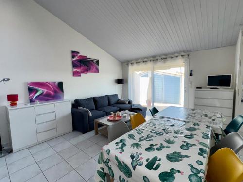 un salon avec un lit, un canapé et une table dans l'établissement Maison pour 8 à 200m de la plage avec Wi-Fi gratuit - Saint Hilaire de Riez - FR-1-323-407, à Saint-Hilaire-de-Riez