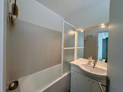 une salle de bain blanche avec un lavabo et un miroir dans l'établissement Appartement rénové 1 chambre avec balcon et parking privé à Saint-Jean-de-Monts - FR-1-323-413, à Saint-Jean-de-Monts