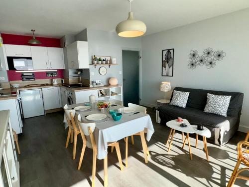 Il comprend un salon et une cuisine avec une table et un canapé. dans l'établissement Appartement rénové 1 chambre avec balcon et parking privé à Saint-Jean-de-Monts - FR-1-323-413, à Saint-Jean-de-Monts