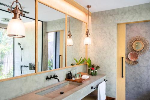 a bathroom with a large mirror and a sink at JATI Koh Russey in Sihanoukville