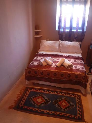 a bedroom with a bed with two pillows on it at Dar INNÂ in Aït Benhaddou