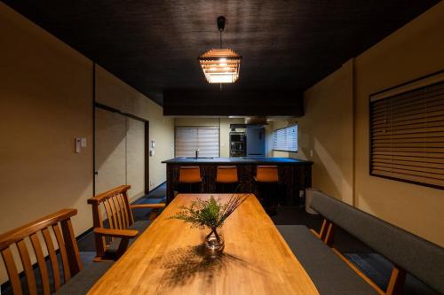 a room with a wooden table with a vase on it at 次郎邸 京都駅前の大きな一軒家 駐車場2台 寝室5部屋 トイレお風呂3台 in Kyoto
