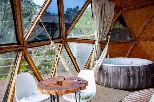 a room in a tree house with a wooden table and chairs at Vespertino Ecohotel Glamping in Vergara