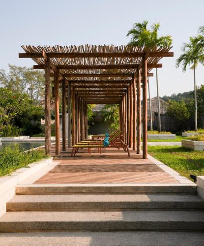 a wooden pavilion with benches and palm trees in a park at JATI Koh Russey in Sihanoukville