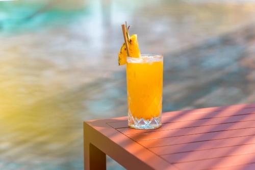 a glass of orange juice sitting on a table at JATI Koh Russey in Sihanoukville