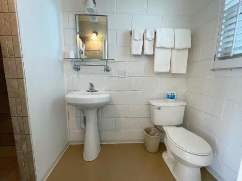 a white bathroom with a toilet and a sink at Mt Carmel Motel in Southern Utah in Mount Carmel