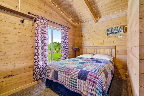 マウント・カーメルにあるThe Park Cabin at Mount Carmel Motel and RV Parkの丸太小屋のベッドのある寝室