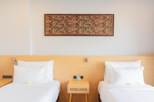 two beds in a hotel room with a picture on the wall at Sand & River Hotel - แซนด์ แอนด์ ริเวอร์ หนองคาย in Ban Pak Som